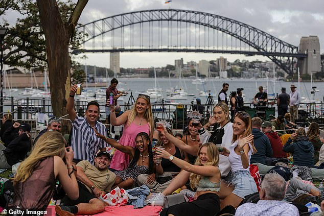 Sydney's New Year's Eve fireworks displays at the Harbour Bridge are set to boost the city's economy by $151million (pictured, New Year's revellers in 2022)