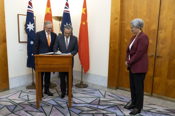 Prime Minister Anthony Albanese, Chinese Foreign Minister Wang Yi and Foreign Affairs Minister Penny Wong, during the signing of the visitors book.