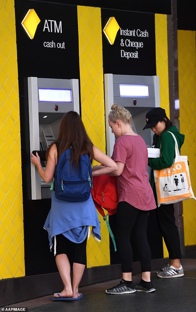 Commonwealth Bank (CBA) has lowered the maximum amount customers could deposit into their accounts from $1,000 to $750 a day (pictured, people in Brisbane use ATMs)