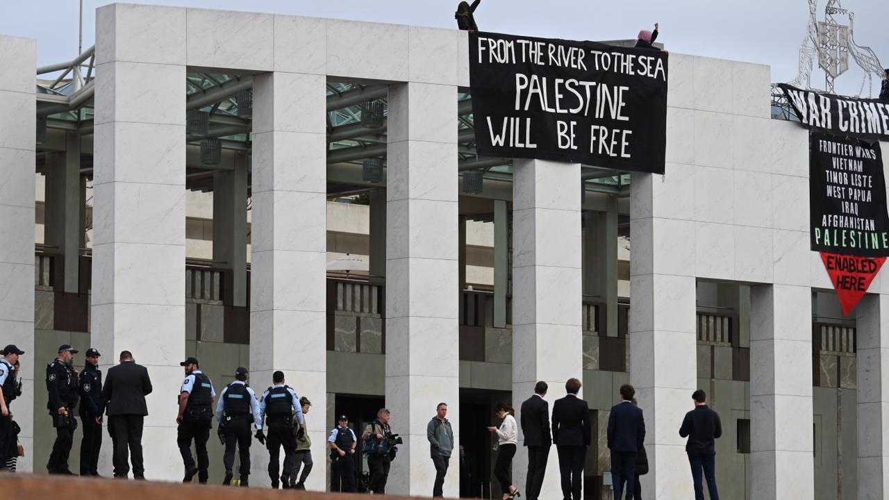 Pro-Palestine protesters have taken to the roof of Parliament House to unfurl a banner. Picture: NewsWire/ Martin Ollman