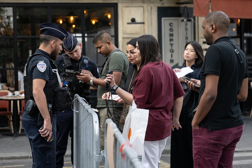 Police check QR codes on people's phones at a security checkpoint