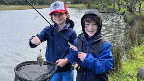 Ben and ﻿his older brother Russell, pictured fishing on the banks of a river.