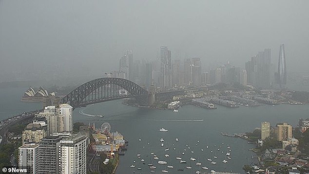 The Sydney Harbour Bridge and Opera House are seen shrouded by clouds and fog on Monday