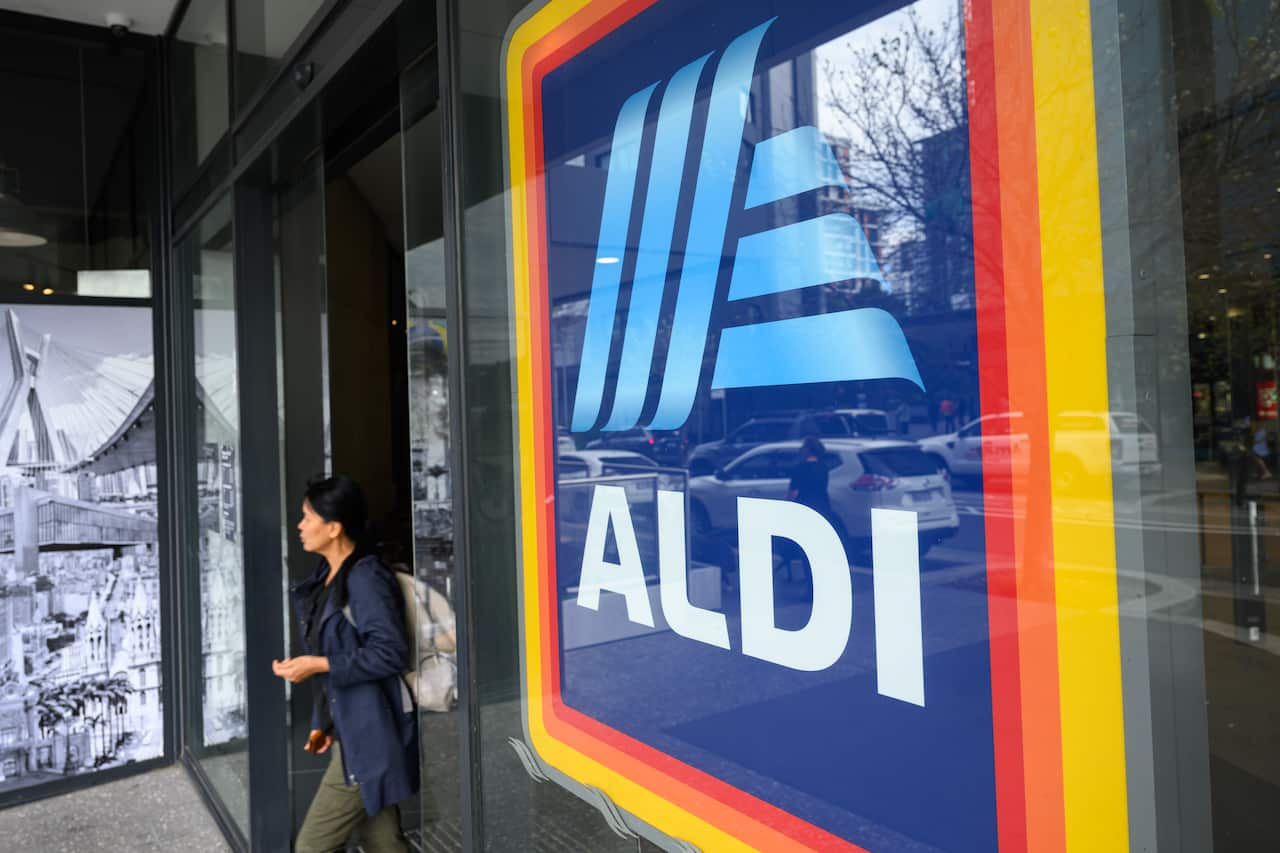 A woman walks out on an Aldi store.