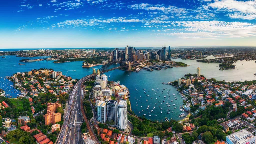 Panorama Aerial view Scene of Crowded Traffic over Express way heading to Sydney Harbour Bridge with Opera House, Lavender bay with many Yacht and Circular Quay