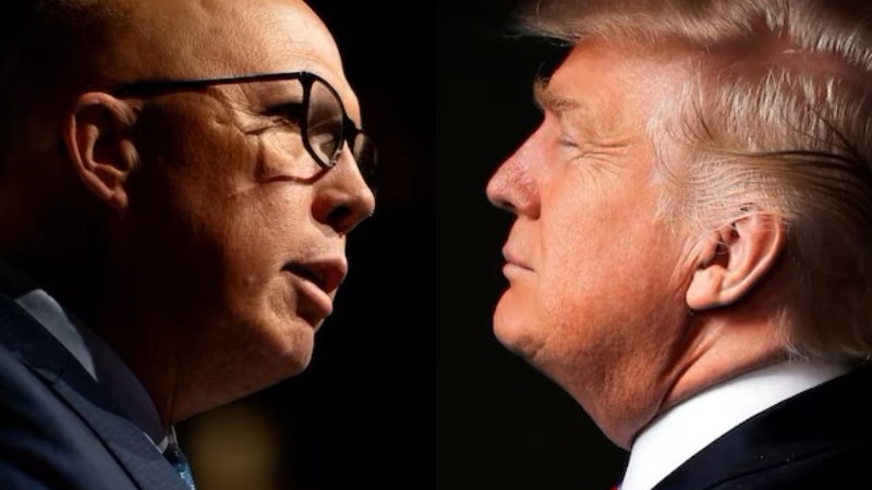 man with a bald head and glasses faces a man with blond hair