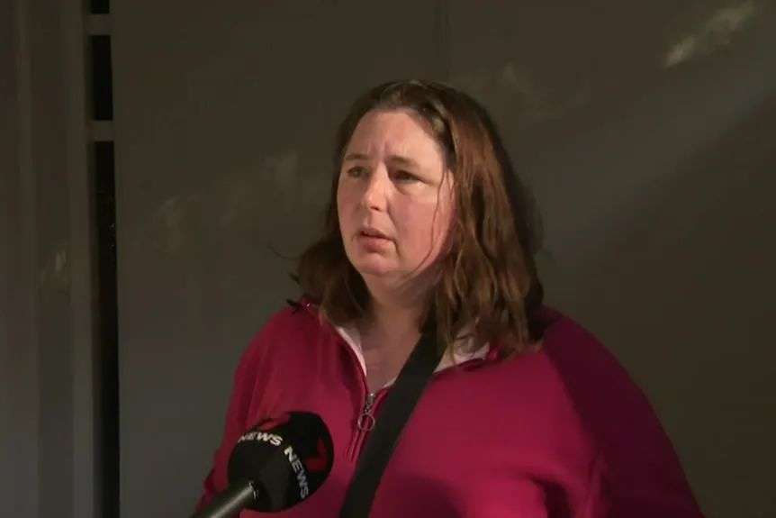 A woman with a 7 News microphone in front of her face.