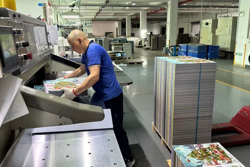 A man in blue in front of a production line.