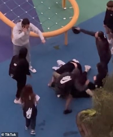 两名年轻人跳到这名女子身上，而她的男伴则大声呼救