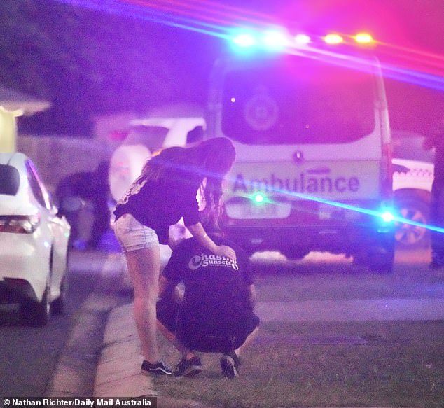 A distressed man was seen on his hands and knees in despair as others comforted him in the wake of the tragedy
