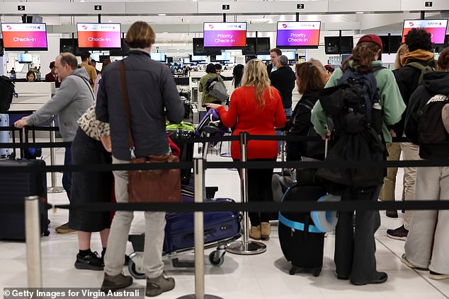 An urgent travel warning has been issued for Australians travelling to or transiting through Qatar (pictured, travellers at Sydney International Airport)