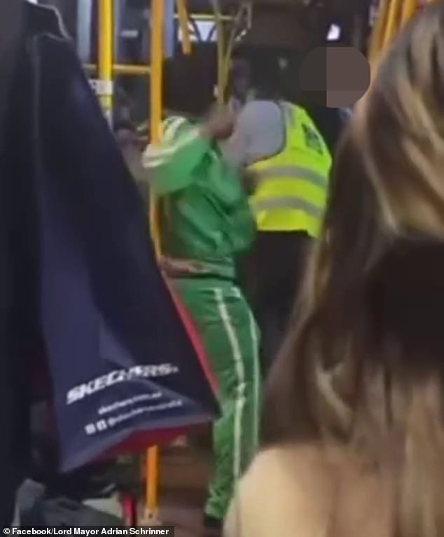 The bus driver appeared to be punched in the face by the man in the green jumpsuit (pictured)