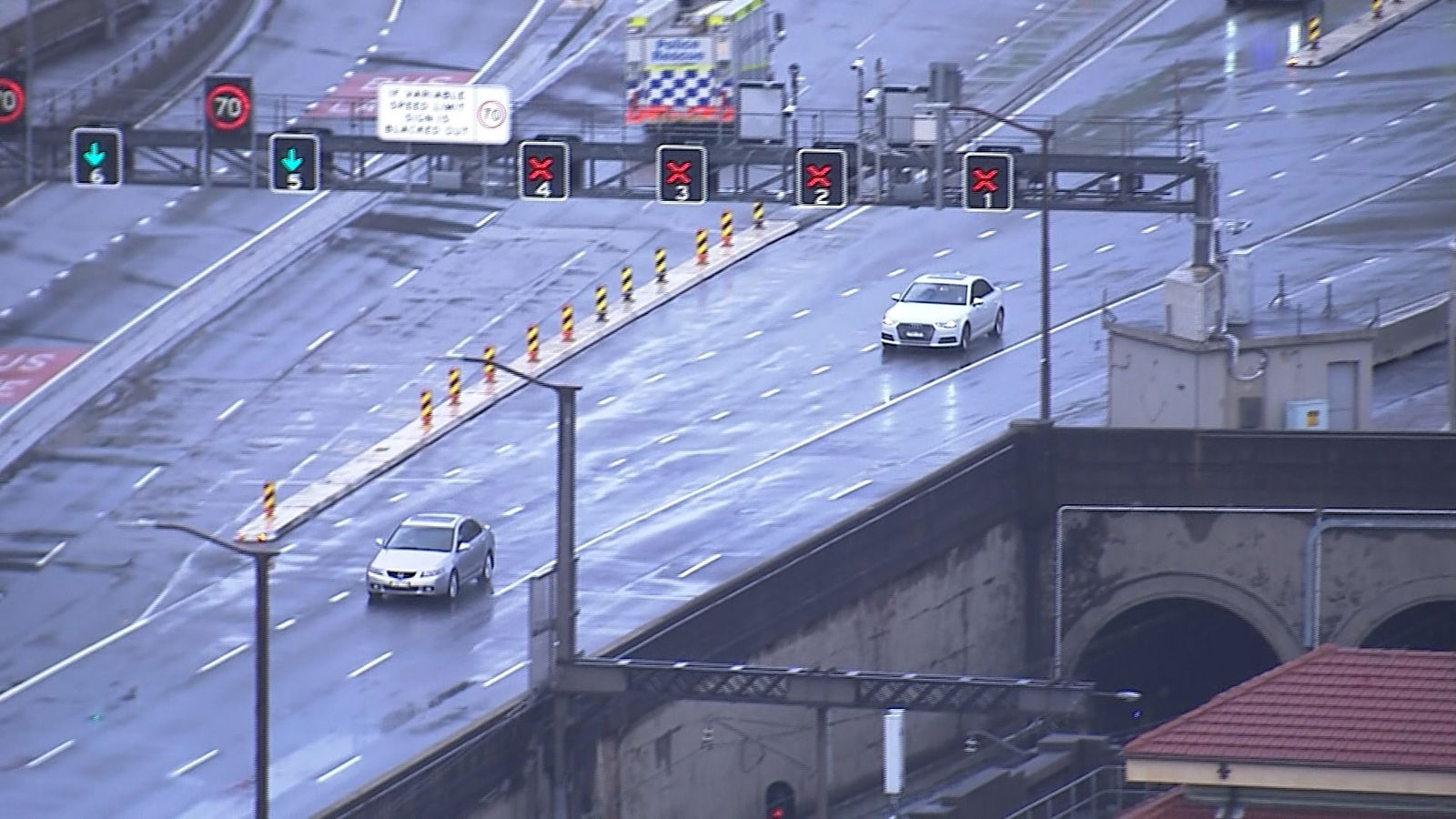Two cars on wet empty road.