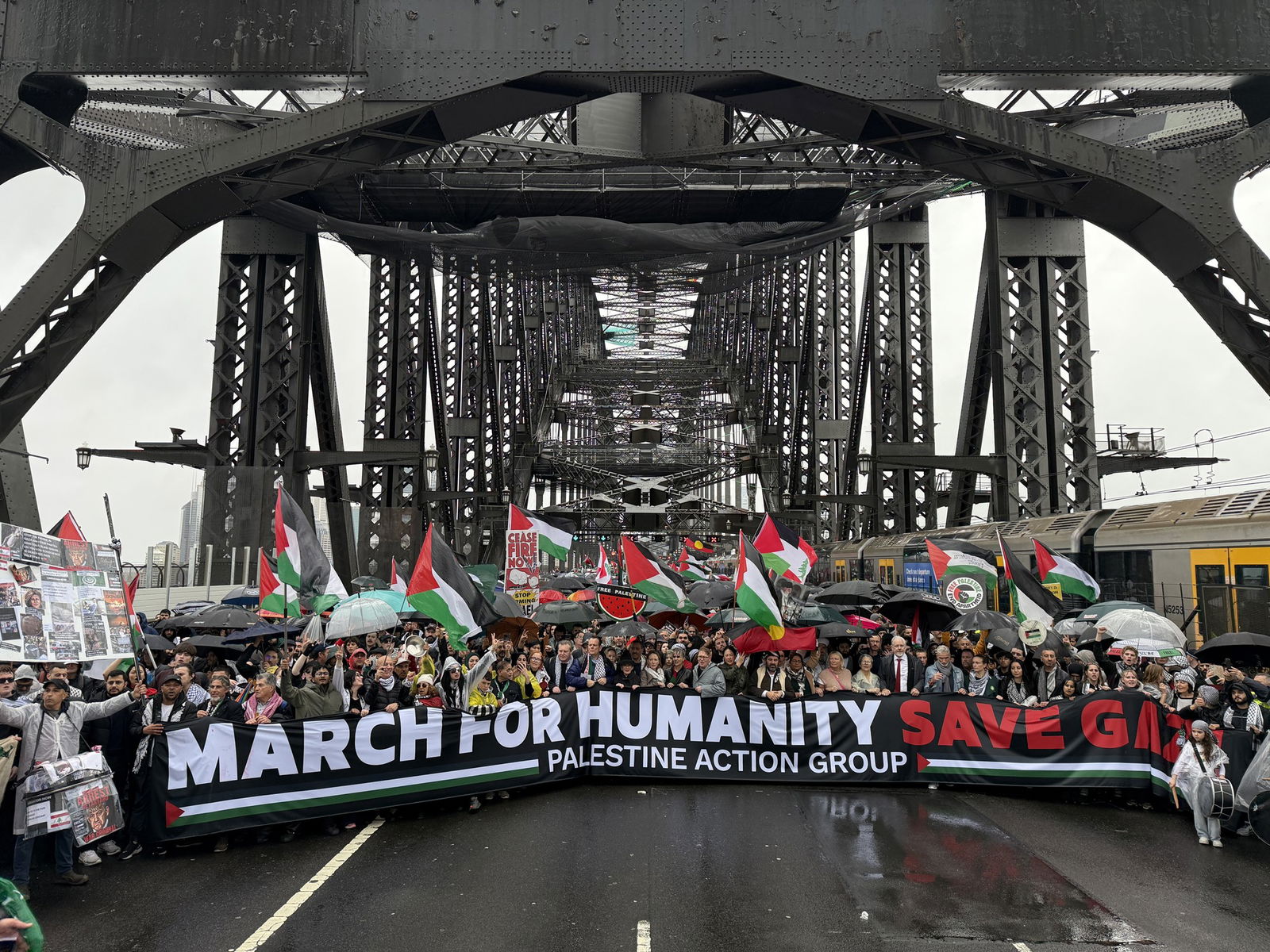 抗议者在海港大桥上举着“为人类游行,拯救加沙”的横幅