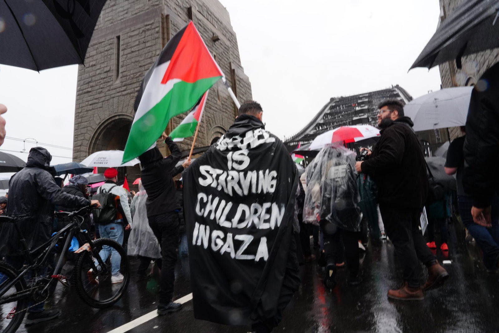 一名抗议者穿着一件斗篷,上面写着:“以色列正在让加沙儿童挨饿”