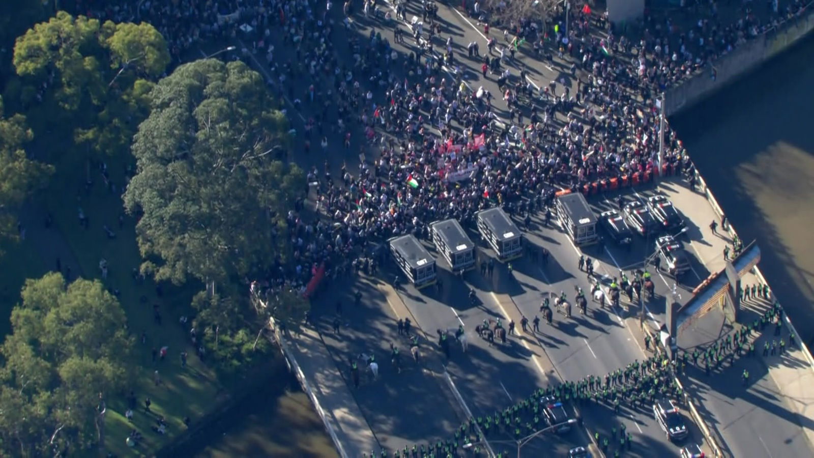 从空中拍摄的照片中可以看到,大批人群挤向一排防暴警察、黑色警车和另一排警察。