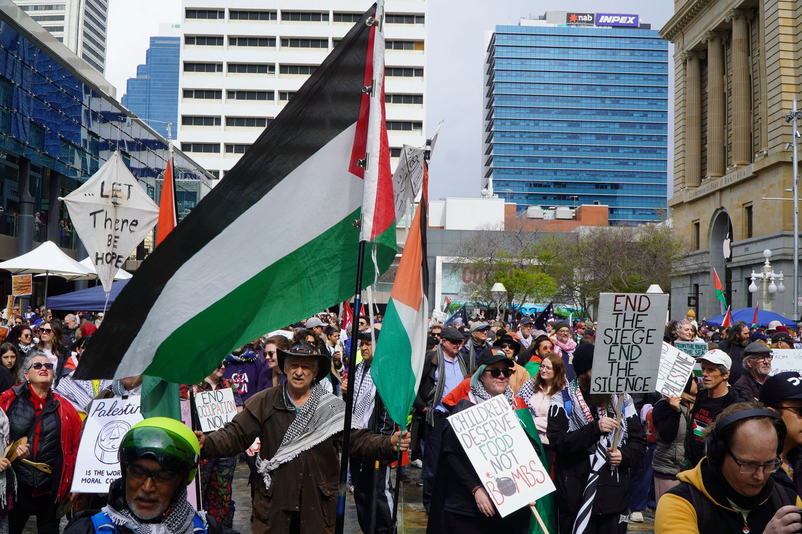 抗议者在城市广场游行，挥舞着巴勒斯坦国旗