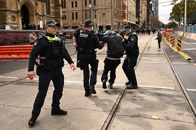 epa12338728 2025 年 8 月 31 日星期日,在墨尔本举行的澳大利亚反移民游行集会期间,维多利亚州警方在弗林德斯街车站外带走了一名男子。EPA/JOEL CARRETT 澳大利亚和新西兰出局