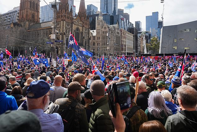 澳大利亚墨尔本 - 8月31日:2025年8月31日,反移民抗议者在澳大利亚墨尔本弗林德斯街车站外高举标语牌,挥舞着澳大利亚国旗。各种右翼和民族主义团体呼吁在8月31日在澳大利亚多个城市举行反移民集会,理由是他们担心边境政策和文化融合问题。警方和社区领袖警告称,由于支持多元化组织的反抗议活动预计将同时进行,可能会发生冲突。(图片来自Asanka Ratnayake/Getty Images)