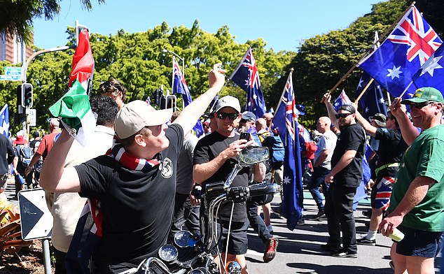 2025年8月30日星期六,在布里斯班举行的澳大利亚反移民游行集会上,一名男子扔掉了从反抗议者那里偷来的巴勒斯坦国旗。(AAP图片/Jono Searle)无存档