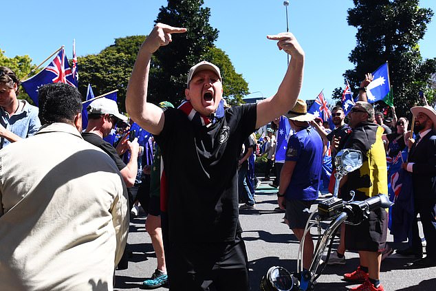 2025年8月30日星期六,布里斯班,一名男子在澳大利亚反移民游行集会上向反抗议者示意。(AAP图片/Jono Searle) 暂无存档