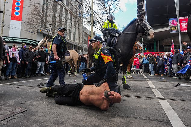澳大利亚墨尔本——2025年8月31日:一名抗议者在澳大利亚墨尔本被捕。各种右翼和民族主义团体呼吁在8月31日在澳大利亚多个城市举行反移民集会,理由是他们担心边境政策和文化融合问题。警方和社区领袖警告称,由于支持多元化的组织的反抗议活动预计将同时进行,可能会发生冲突。(图片来自Asanka Ratnayake/Getty Images)