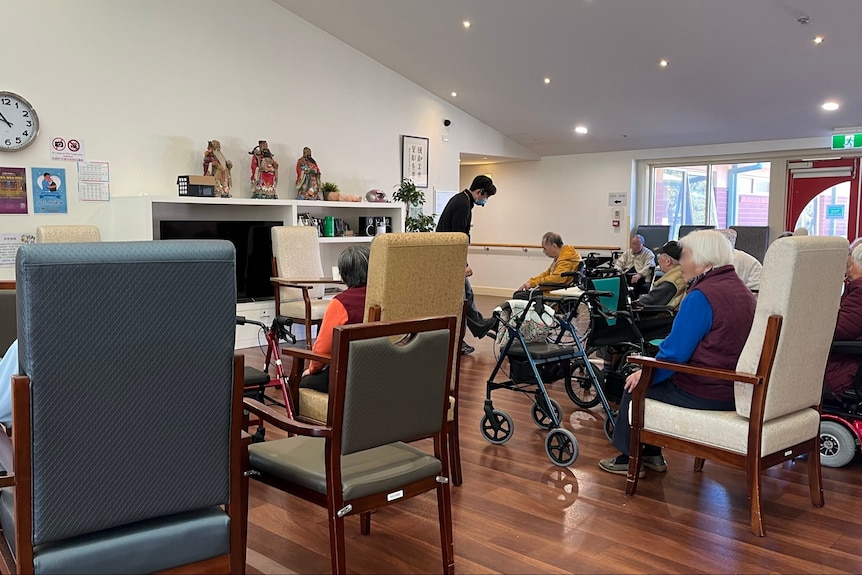 aged care residents gather in the hall room
