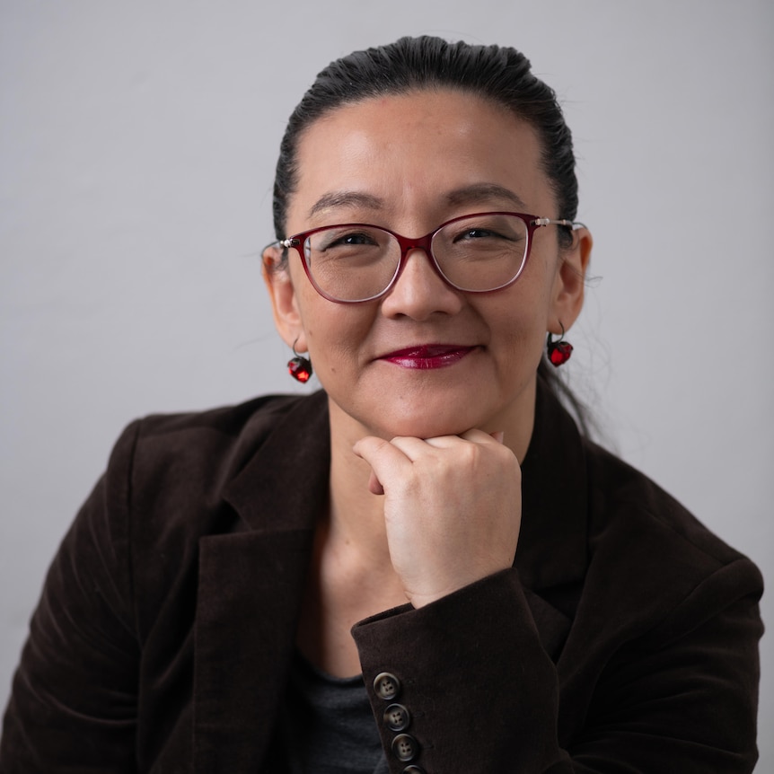 A woman with glasses smiling