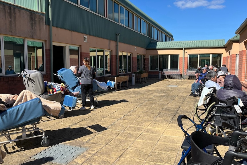 a group of elderly residents enjoy the sunshine