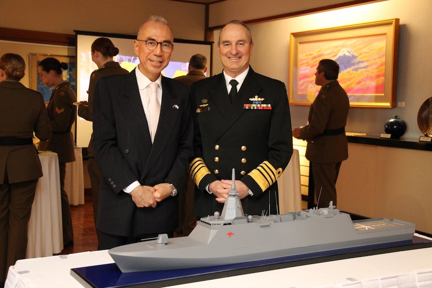 Two men in suits formally pose for the camera