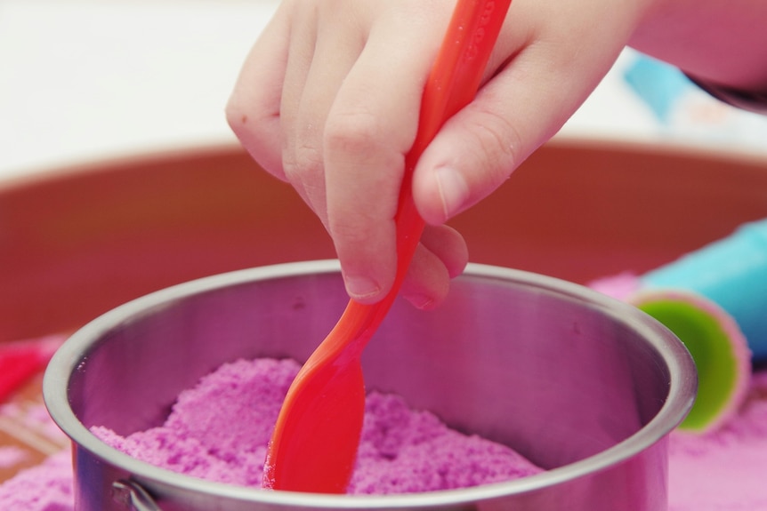 Pink sand in a dish with a spoon. 