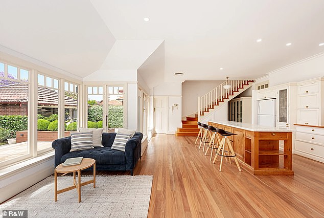 It also features a large island bench with stone bench tops and timber cabinetry