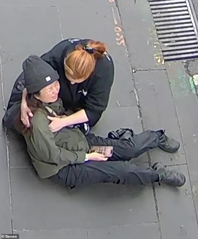 Sushi chef Wan Lai is comforted after allegedly being stabbed in the chest