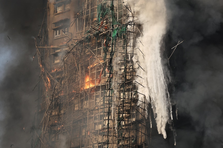 Bamboo scaffolding burns and falls to the ground from a high-rise apartment building