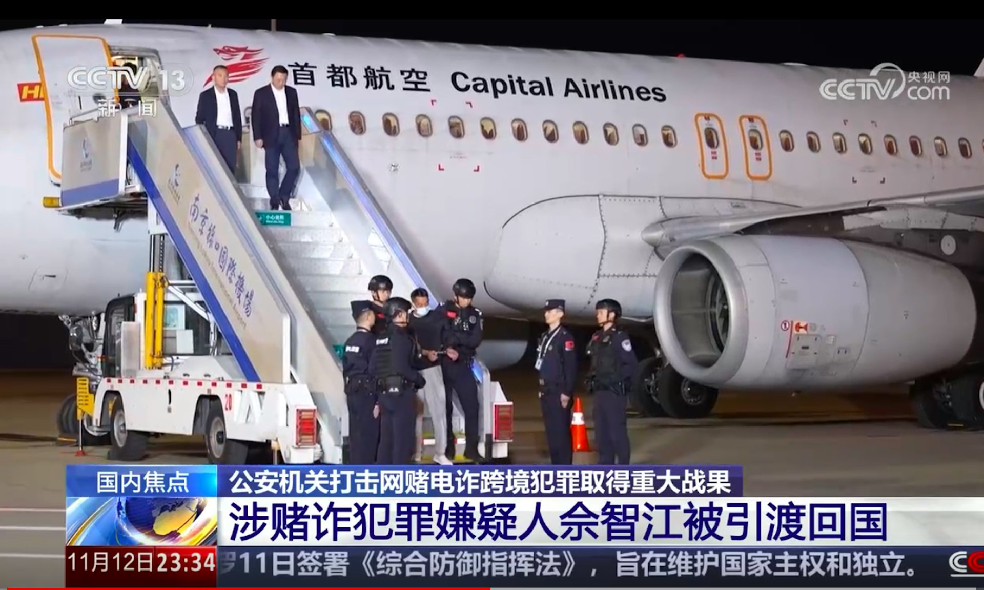 图为2025年11月12日，载著佘智江的客机昨晚降落南京禄口国际机场，他随即被警方锁上手扣，押解落机及离开。（央视截图）