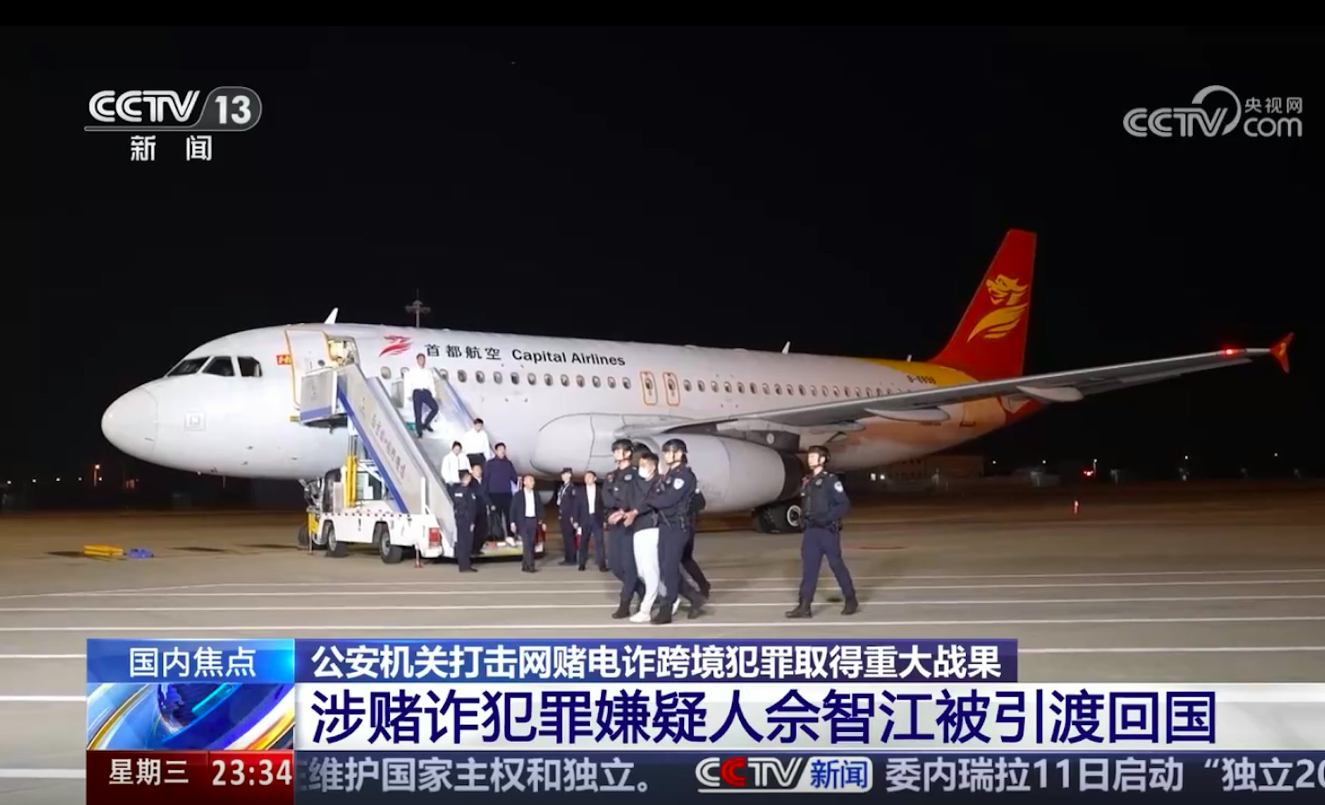 图为2025年11月12日，载著佘智江的客机昨晚降落南京禄口国际机场，他随即被警方锁上手扣，押解落机及离开。（央视截图）