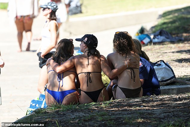 A group of bikini-clad women were seen consoling each other at the water's edge