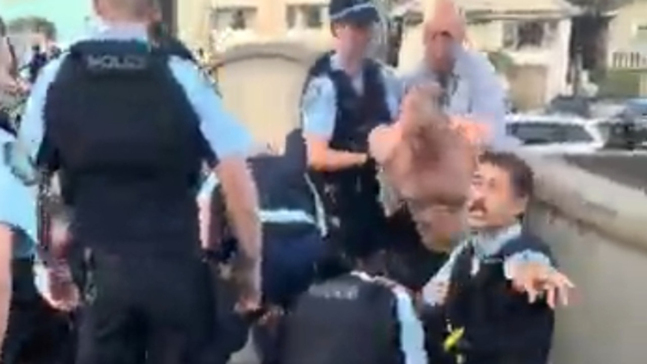 警察正在照料倒在地上的两名男子。