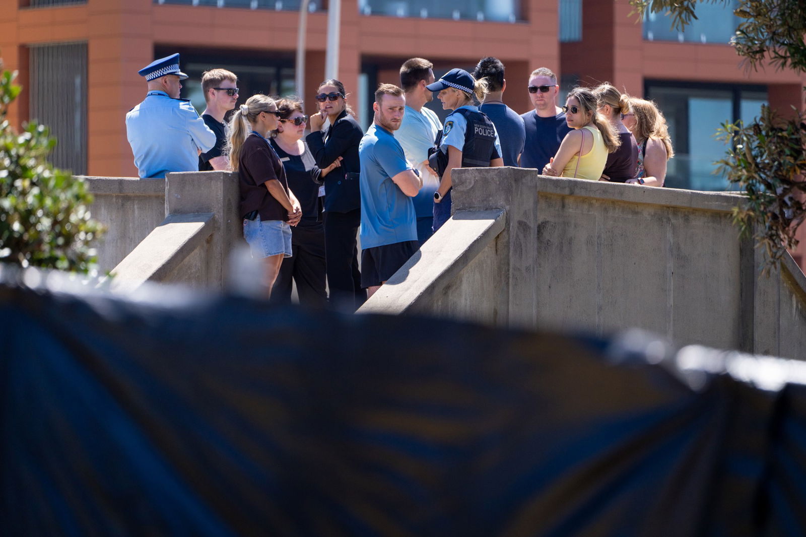 一群人站在桥上,其中包括一些警察。