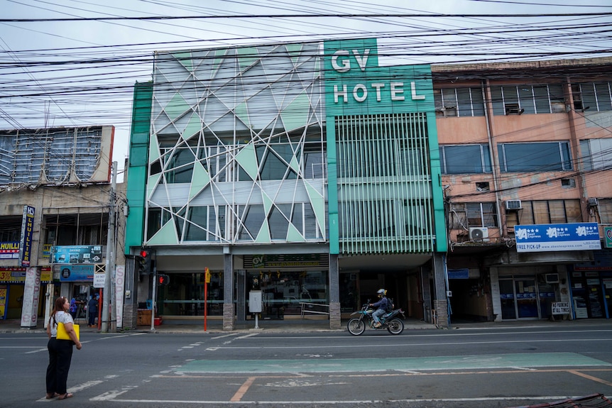 A small hotel, with a green exterior, says