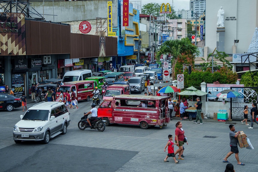 Vehicles and people move around in a public square