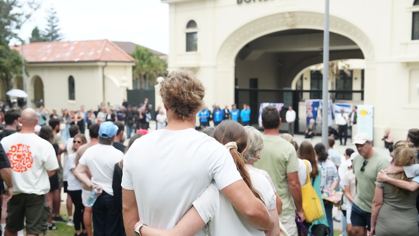 Hundreds of people lay flowers in front of Bondi beachside pavilion.