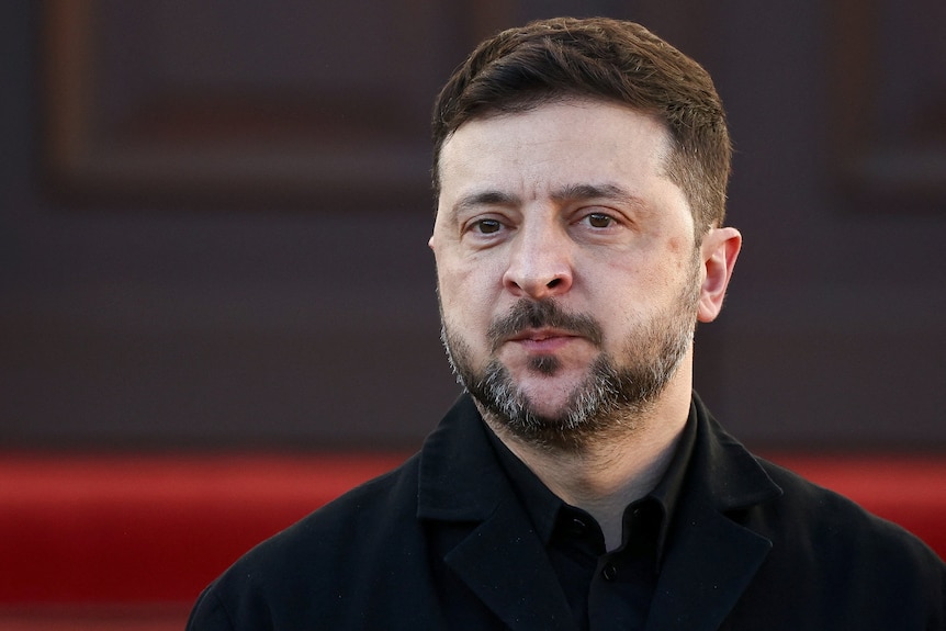 A close up of Volodymyr Zelenskyy in a black shirt.