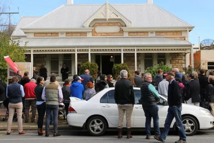 Front of house at auction, crowd has gathered