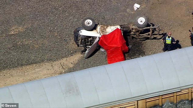 The ute was pictured lying on its side beside the train tracks