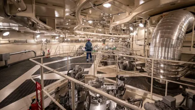 从背后看一名男子走过核电厂。