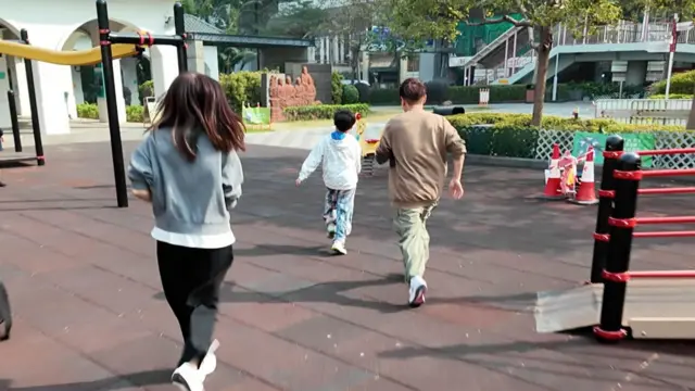 Aiden一家三口正在奔向一个玩乐设施