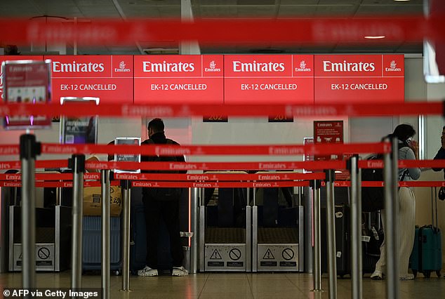 伊朗空袭后,数千名乘客滞留,值机柜台显示航班取消信息。