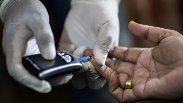 2017年7月13日，星期四，在印度哈里亚纳邦塔那卡兰村，一名印度公共卫生基金会的工作人员正在为一位患者进行血糖检测。