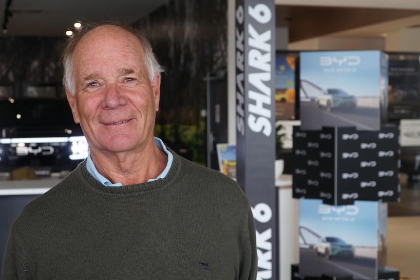 an older man looks into camera